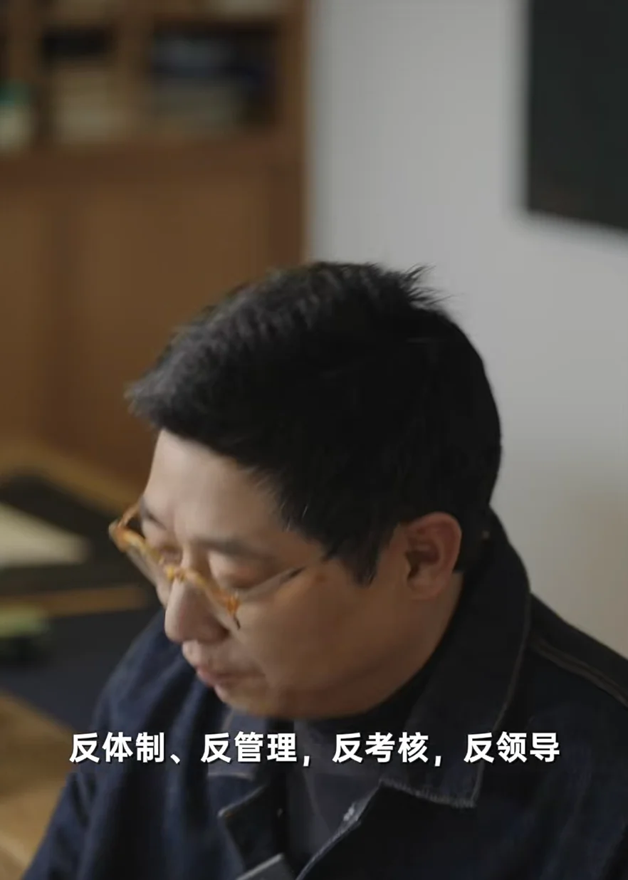 徐沪生访谈近景,字幕为反体制、反管理、反考核、反领导